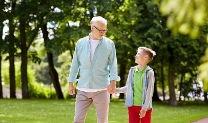 grandfather and grandson walking at summer park