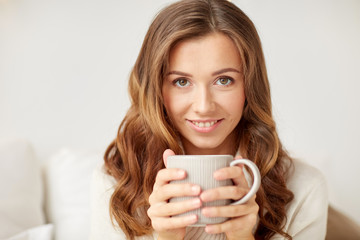 close up of happy woman with coffee cup at home