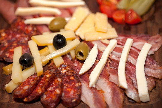 Meat appetizer with bacon, sausage, olives and cheese