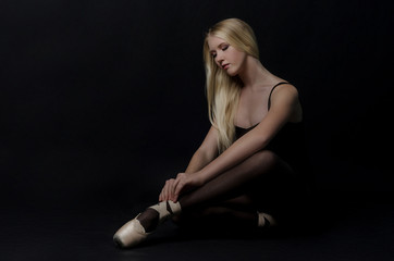 Naklejka premium Beautiful graceful blond dancer in bright satin pointe.