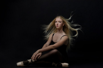 Naklejka premium Beautiful graceful blond dancer in bright satin pointe.