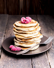 Stack of pancakes with berries on plate Old wooden background