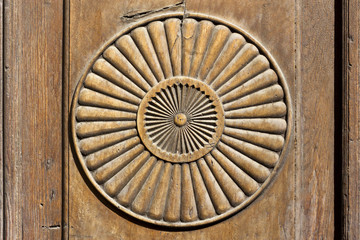 Simple circle shape representing the sun, carved on a wooden surface.