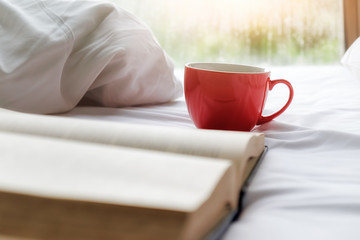 A cup of coffee on bed with copy space. Morning with a book. Relaxing concept. Retro filter effect,soft focus,selective focus...