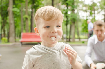 baby boy eating cotton candy with his father
