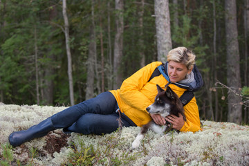 Fototapeta premium Woman-tourist is laying on the forest meadow with a dog