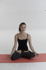 Fototapeta premium Beautiful and smiling girl showing asana yoga lotus pose