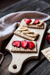 Fruity toast on wooden background. Strawberries, bread, butter and cheese.Vintage style
