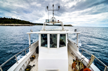 Industrial fishing boat ship on the sea with dramatic clouds.