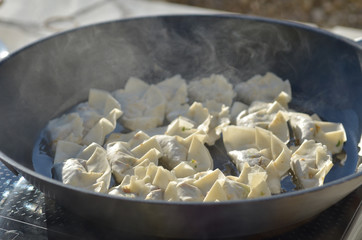 Making homemade Gyoza - Japanese Dumplings in frying pan.