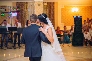 Happy bride and groom and their first dance, wedding in the elegant restaurant with a wonderful light and atmosphere
