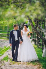 Groom and Bride in a park. wedding dress. Bridal wedding bouquet of flowers. Newlyweds on nature.