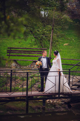 wedding. beautiful couple kissing in the sun near lake and pier. Ceremony bride and groom holding hand each other.