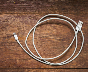 White usb mobile charging cable on wood table