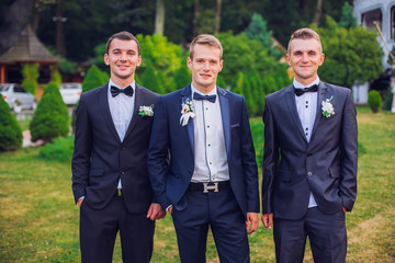 Groomsmen standing on the wedding ceremony outdoors