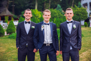 Groomsmen standing on the wedding ceremony outdoors
