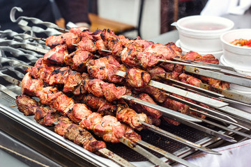 Marinated shashlik preparing on a barbecue grill over charcoal. Shashlik or Shish kebab popular in Eastern Europe. Shashlyk (skewered meat) was originally made of lamb. Roast Beef Kebabs On BBQ Grill.