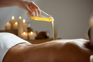 Honey pouring on girl's naked back in spa salon. - Powered by Adobe