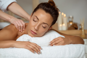 Fototapeta na wymiar Young attractive girl having massage relaxing in spa salon.