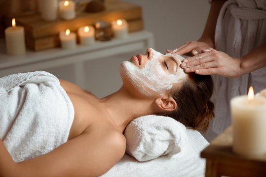 Young beautiful girl in mask for face relaxing in spa salon.