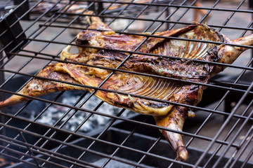 Appetizing grilled lamb on the spit. Roasted pig on traditional barbecue. Roasting barbecue is...