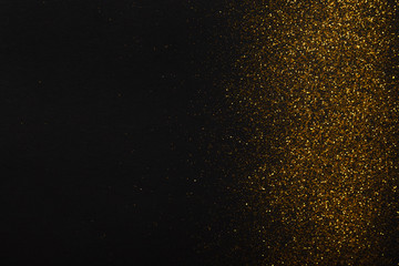 Fototapeta na wymiar Golden glitter sand texture border on black, abstract background.