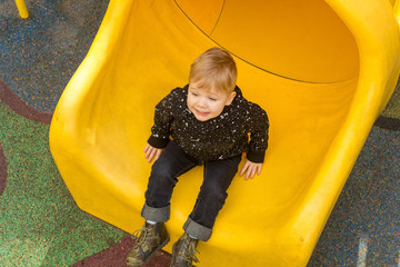 Little boy is sliding at the playground