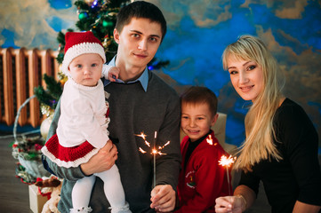 Portrait of friendly family looking at camera on Christmas evening