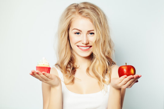 Smiling Woman with Healthy and Unhealthy Food. Difficult choice.