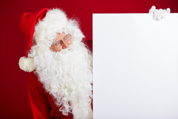 Santa Claus pointing in blank advertisement banner isolated on r