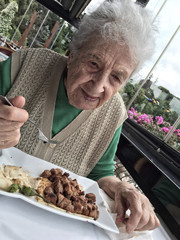 happy senior woman having lunch in a restaurant