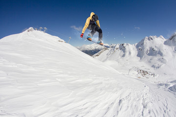 Fototapeta na wymiar Snowboard rider jumping on mountains. Extreme snowboard sport.