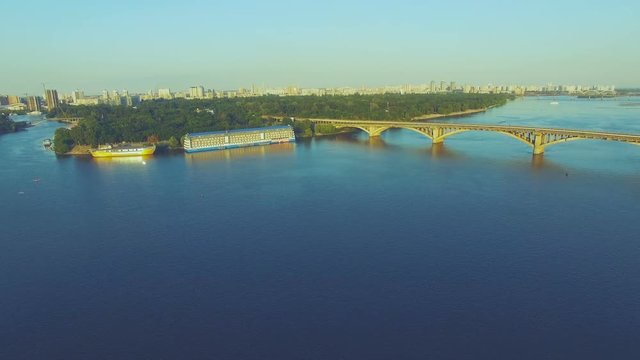 Aerial Drone Flight Footage: Dnipro river with Metro Bridge and cityscape at sunset. Magestic landscape. Kiev, Ukraine, Europe. 4K resolution.