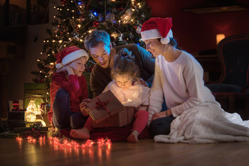 Obraz na płótnie Canvas At christmas a lovely family find a digital tablet in their gift