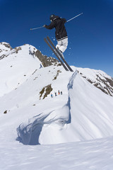 Naklejka na ściany i meble Ski rider jumping on mountains. Extreme freeride sport.