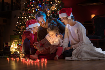 Obraz premium At christmas a lovely family find a digital tablet in their gift
