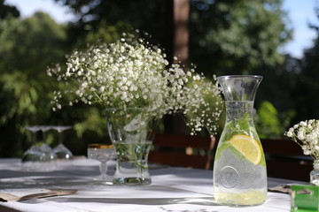 Sommerlicher Tisch mit Schleierkrau/Brautschleier  und Wasserkaraffe mit Zitrone