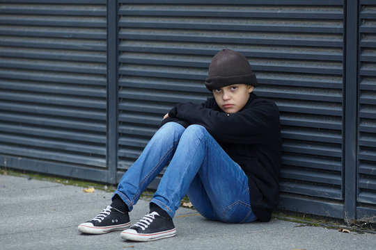 dramatic portrait of a little homeless boy on the street