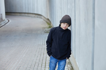 dramatic portrait of a little homeless boy on the street