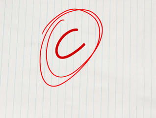 C grade written in red on notebook paper