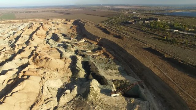 Flying over the iron ore quarry. Excavator digs for iron ore quarry. aerial survey