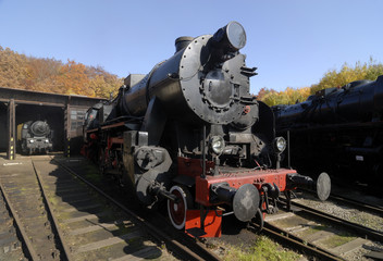 Obraz premium Old Vintage Steam Locomotive At The Train Depot 