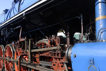 Steam locomotive wheels and rods closeup. Detail of mechanical parts, wheels and equipment of the train.
