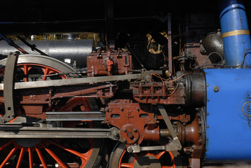 Steam locomotive wheels and rods closeup. Detail of mechanical parts, wheels and equipment of the train.
