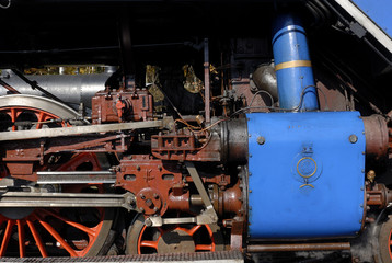 Steam locomotive wheels and rods closeup. Detail of mechanical parts, wheels and equipment of the train.
