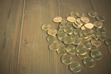 Gold coins. On wooden background.