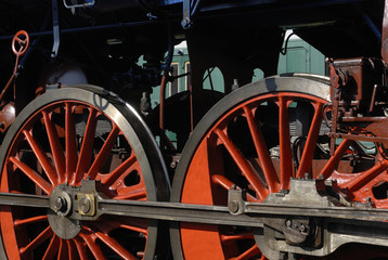 Steam locomotive wheels and rods closeup. Detail of mechanical parts, wheels and equipment of the train.
