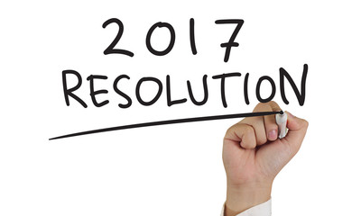 Photo image of businessman hand writing 2017 new years resolutions isolated on white