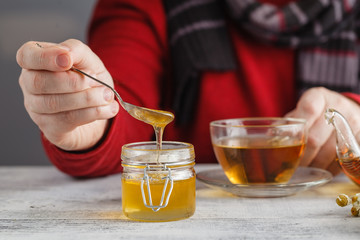 Honey in a glass jar and herbal tea. Honey and tea. Soft focus
