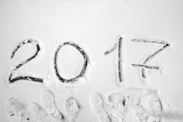 inscription 2017 on the snow with footprints top view